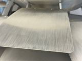 a close up of a metal cutting board on a machine
