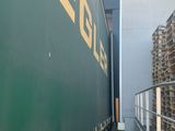 a green semi truck that is parked next to a building