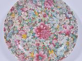 a colorful plate with flowers on it on a white surface