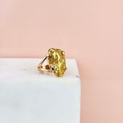 a gold ring sitting on top of a marble block