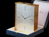 une horloge posée dans une boîte sur une table