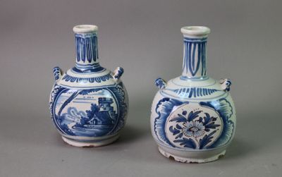 pair of blue and white vases sitting on top of a gray surface