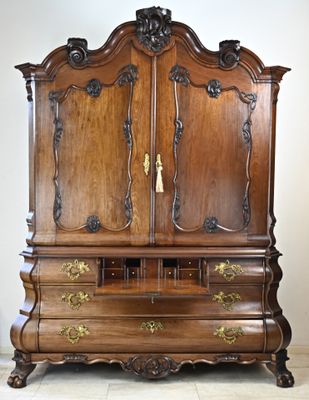 une grande armoire en bois surmontée d'une poignée dorée