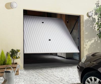 une voiture garée devant un garage dont la porte est ouverte