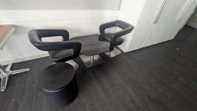 deux chaises noires assises l'une à côté de l'autre dans une pièce