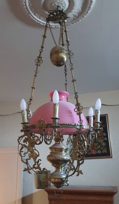 un lustre surmonté d'une tirelire en forme de cochon rose