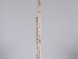 an old silver flute with a flute stand on top of it