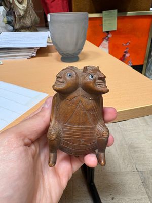 a person holding a small statue of a turtle
