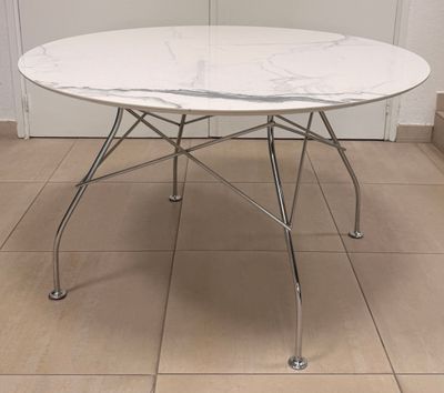 a white marble table with chrome legs and a white table top