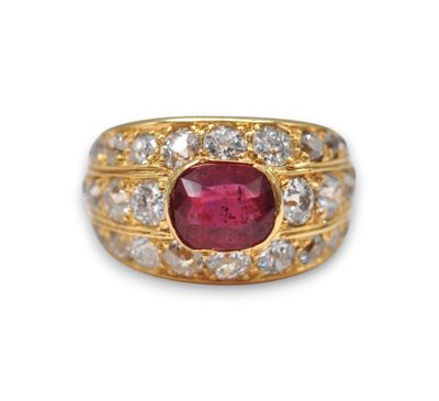 gros plan d'une bague en or avec un rubis et un diamant au centre