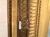 an image of a gold framed mirror with ornate carvings on it