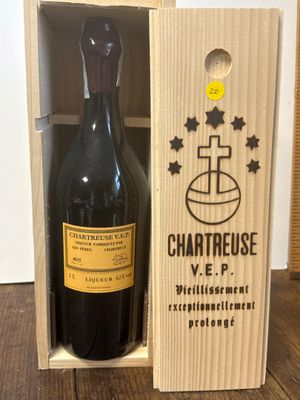 une bouteille de vin dans un coffret en bois, posée sur une table en bois