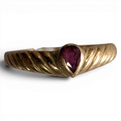 an image of a close up of a gold ring with a ruby stone