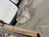 a white truck that is parked next to a pile of wood
