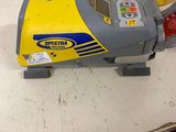 a yellow and gray machine sitting on a table next to a yellow bucket