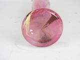 a pink glass object with a gold leaf design on it