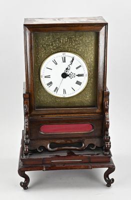 a small wooden clock with roman numerals on it