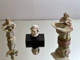 three figurines that are sitting on a glass table