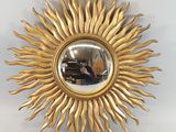 un soleil doré rayonnant, avec un miroir accroché au mur