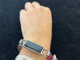 someone is wearing a bracelet that has a silver clasp on it