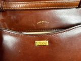 a close up of a brown leather purse with a gold clasp