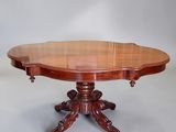 an oval mahogany dining table with two leaves on the top