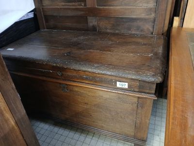 a wooden bench with a wooden seat in the corner of a room