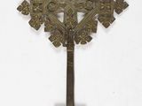 an old metal cross hanging on a wall on a white background