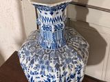 a blue and white vase sitting on a wooden table