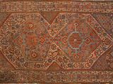 un tapis persan ancien, orné d'un motif complexe sur fond marron