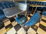 a table and two chairs in the booth of a diner