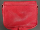 a red leather purse on a black surface