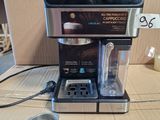 une cafetière posée sur une table à côté d'une tasse