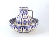 un bol et un pichet bleus et blancs posés sur une table blanche