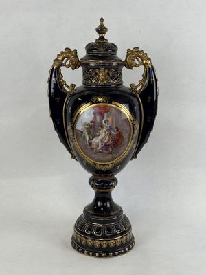 a black and gold vase with a picture of a woman on it