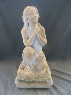 une statue représentant une femme assise sur un rocher, tenant un bébé dans ses bras