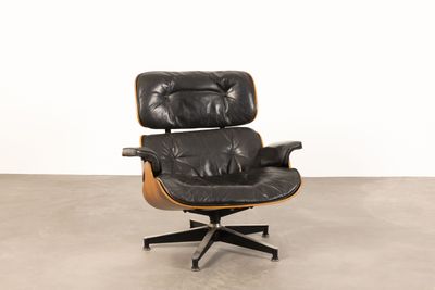 an image of a black leather lounge chair with a wooden base