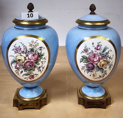 une paire de vases bleus ornés de bordures dorées et de motifs floraux