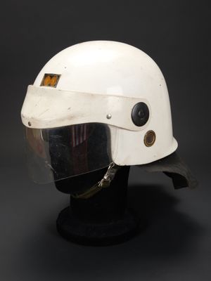 un gros plan d'un casque posé sur un support, sur fond noir