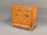 une petite commode en bois sur fond gris