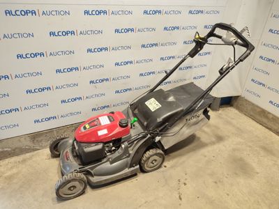 une image d'une tondeuse à gazon garée dans un garage