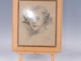 painting of a woman ' s head in a wooden frame on a small easel