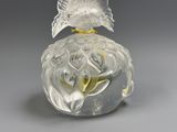 a clear glass vase with a bird on top of it