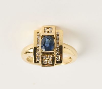 gros plan d'une bague en or avec un saphir et des diamants