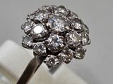 a close up of a ring with a cluster of diamonds on top of it