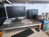 un bureau sur lequel se trouvent un clavier et deux écrans