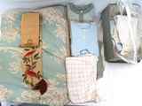 Plusieurs vêtements sont rangés dans une valise posée sur un lit