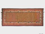 un tapis orange et rose à franges sur fond blanc
