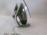 a green and white iron sitting on a white surface