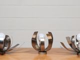 trois sculptures en métal posées sur une table en bois